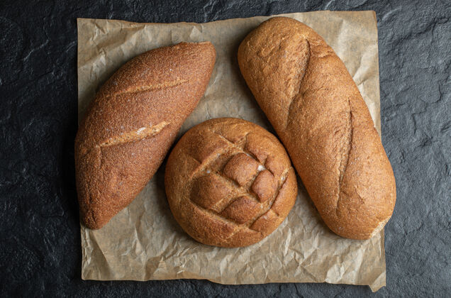黑麦黑底三个不同的面包桌子农业深色