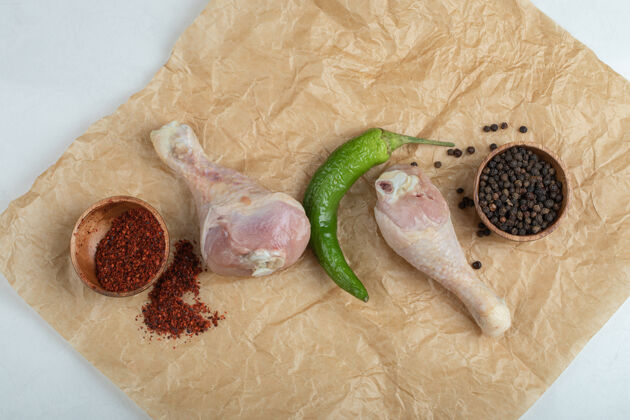 鸡肉新鲜的生鸡腿和香料放在餐纸上自制烧烤鸡腿