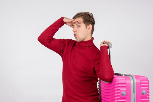 假期白色墙壁上年轻男性背着粉色包的正面图前面情感携带