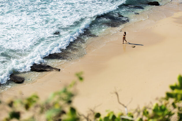 女人美丽的女孩漫步在荒野的海滩上美丽的顶视图放松乐趣自然
