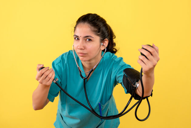 医疗黄墙上年轻女医生用血压计检查血压的正面图护士医疗器械医院