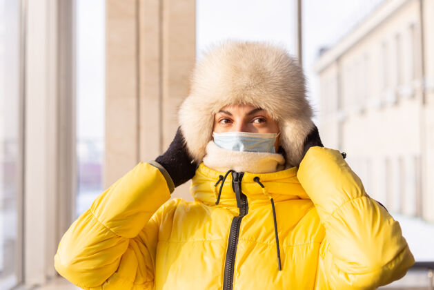预防年轻女子在火车站戴着防护面具 脸上穿着冬装的乘客等待穿戴病毒