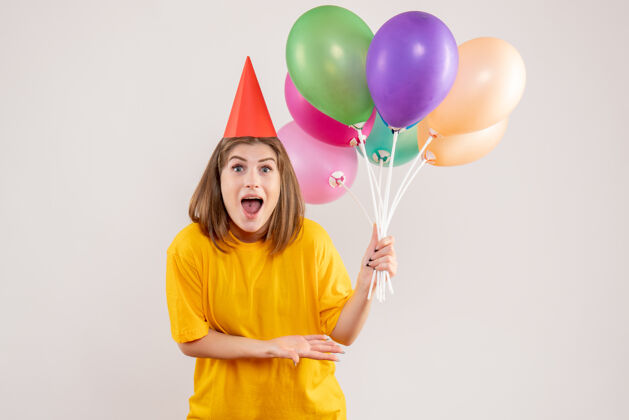 举行手持白色气球的年轻女子生日看法聚会
