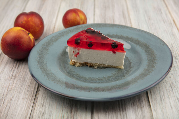 庆典美味的蛋糕在盘子上的俯视图 新鲜的桃子被隔离在灰色的木墙上顶部新鲜食物