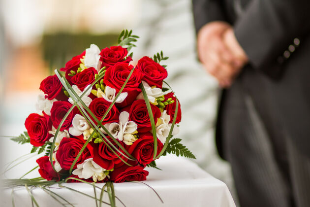 花桌上摆着红玫瑰的婚礼花束花开花玫瑰