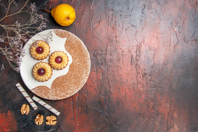 健康顶视图美味的小饼干在盘子里放在深色的桌子上蛋糕甜饼干糖黄色饼干柑橘