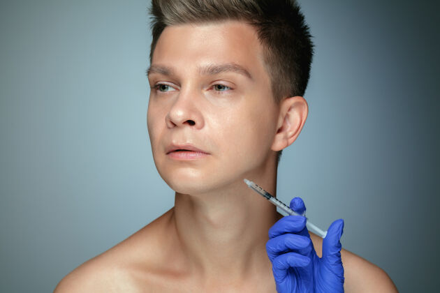 头发隔离在灰色背景上的年轻人的特写肖像填充手术程序 嘴唇和颧骨卫生年轻白种人