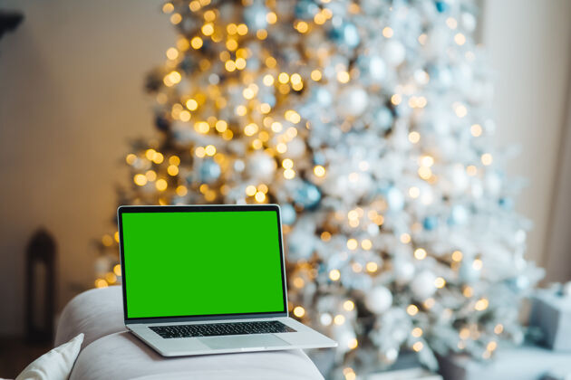 欢乐新年装饰附近有绿色屏幕的笔记本电脑礼物礼物冬天