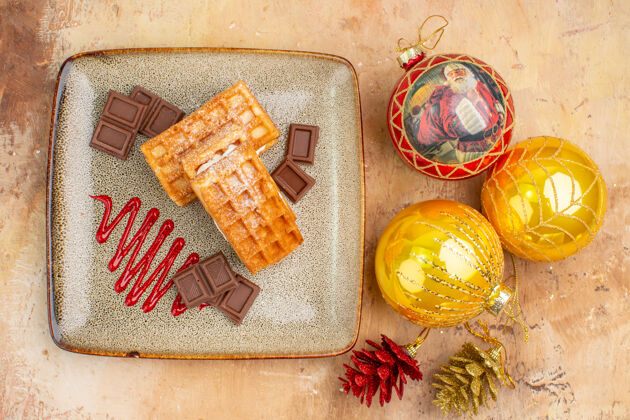 派顶视图美味的华夫饼与巧克力和新年树玩具在灯光背景背景新的包