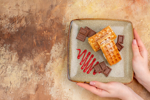 甜点俯瞰美味的华夫饼与巧克力条棕色背景蛋糕饼干容器