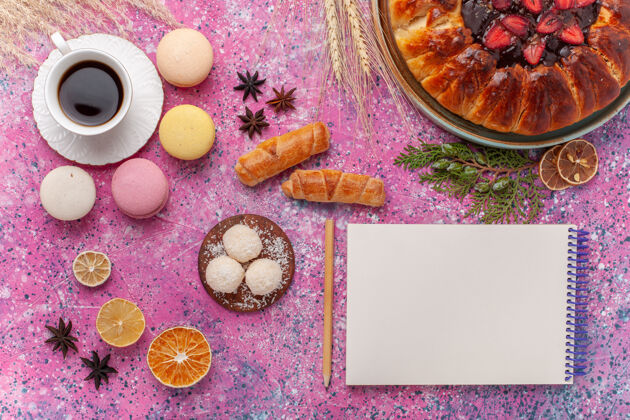糖果顶视图美味的草莓派与一杯茶和麦卡龙粉红水果蛋糕杏仁饼