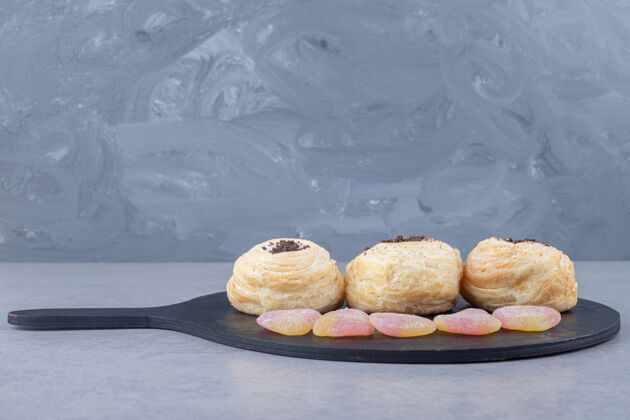甜点在大理石桌上的黑木板上放着肉酱和薄饼果酱美味糕点