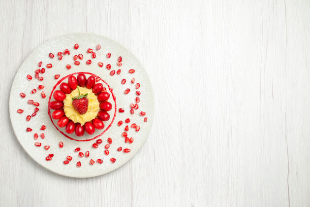 圆形俯瞰美味的奶油蛋糕和山茱萸在白色的桌子上鲜花饼干闪亮