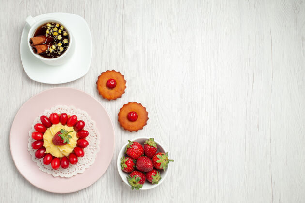 美味俯瞰白色书桌上的奶油蛋糕 水果和一杯茶成熟草莓健康