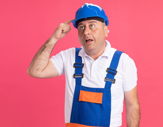 成人给人印象深刻的成年白人建筑工人穿制服把手指放在粉红色的安全帽上建筑工人头盔手指