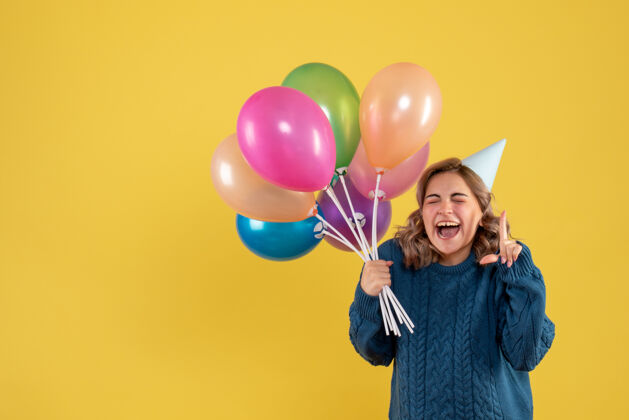 庆祝正面图：带着彩色气球的年轻女性节日工艺乐趣