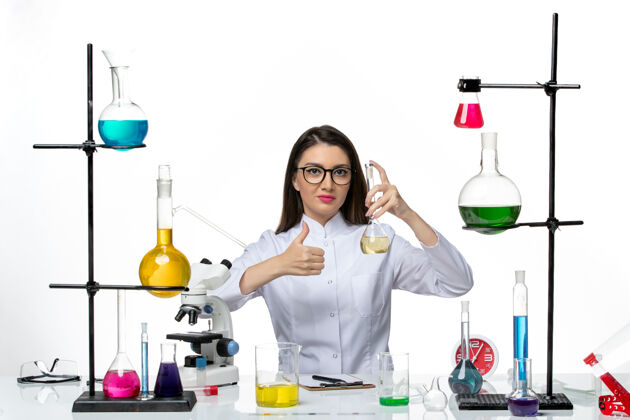 烧杯前视图穿着白色医疗服的女化学家正在处理白色背景的科维科学大流行实验室病毒的解决方案医生实验室病毒