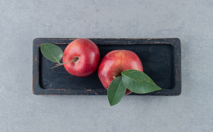 新鲜大理石上放着多汁苹果的小盘子托盘风味水果