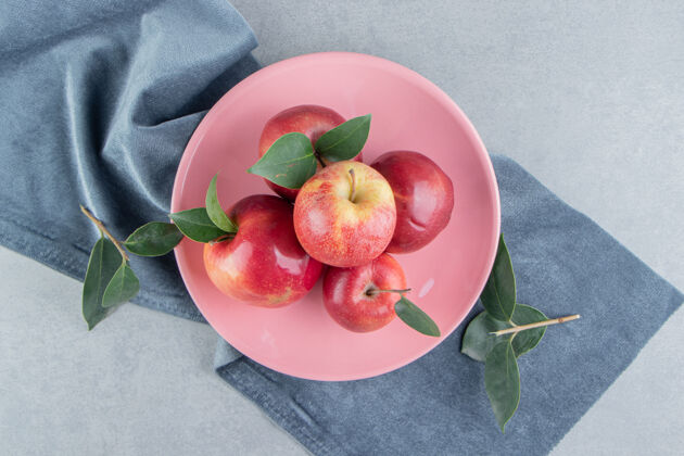 健康在大理石上的一块布料上的盘子上放着一小堆苹果风味水果苹果