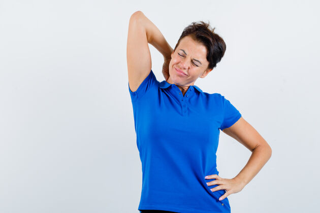 女性一幅身着蓝色t恤的饱受颈部疼痛折磨的成熟女性的肖像 看上去很疲惫中年干净健康