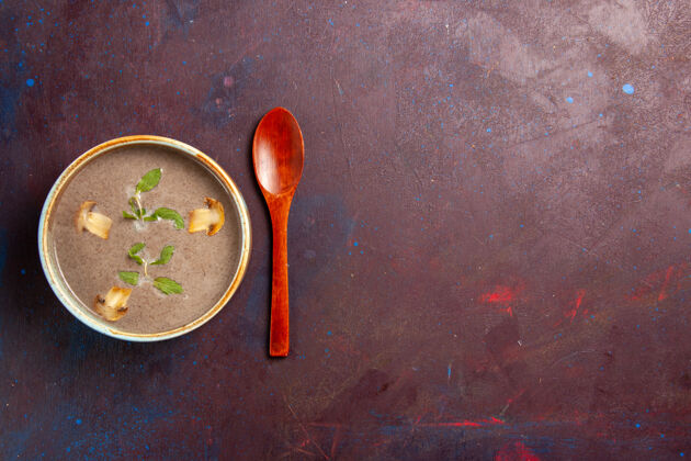 饭菜在黑暗的桌子上的盘子里俯瞰美味的蘑菇汤生的刷子制作