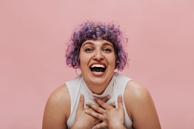 活跃不寻常的紫色发型 带着穿孔和耳环的非凡女人真诚地笑着粉色放松高情感