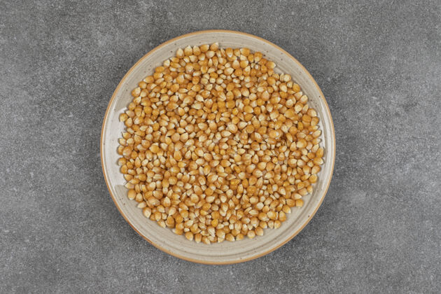 生的一堆生玉米粒放在陶瓷盘子上玉米谷物收获