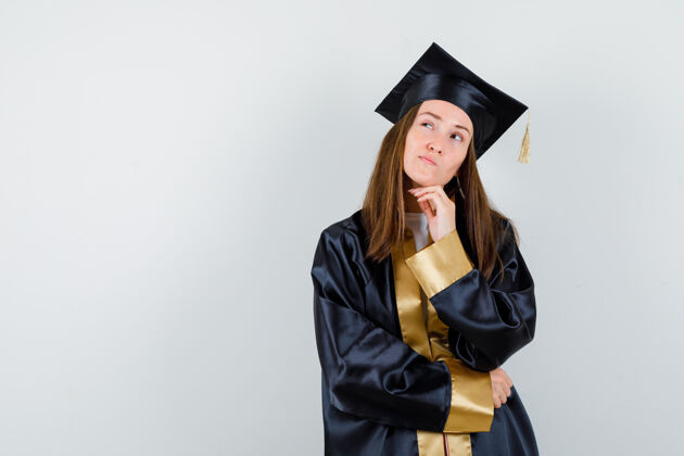 清洁年轻的女毕业生穿着学院服站在思考的姿势 看上去很有思想 很前卫时尚亚洲人毕业