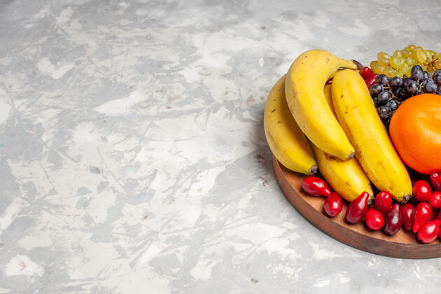新鲜的前视图水果成分香蕉山茱萸和葡萄浅白色背景水果浆果新鲜维生素颜色景观水果农产品