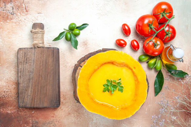 健康俯视汤勺上的南瓜汤菜板上的西红柿柑橘类水果油菜板柑橘美食汤匙
