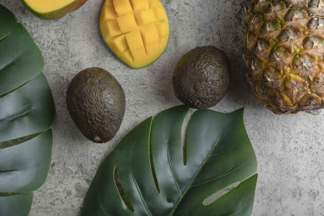 立方体将芒果 椰子 菠萝和成熟的鳄梨切片放在大理石表面上健康椰子鳄梨