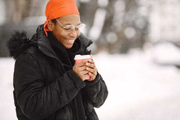 非洲冬天小镇上的女人穿黑夹克的女孩喝咖啡的非洲女人非洲城市商务