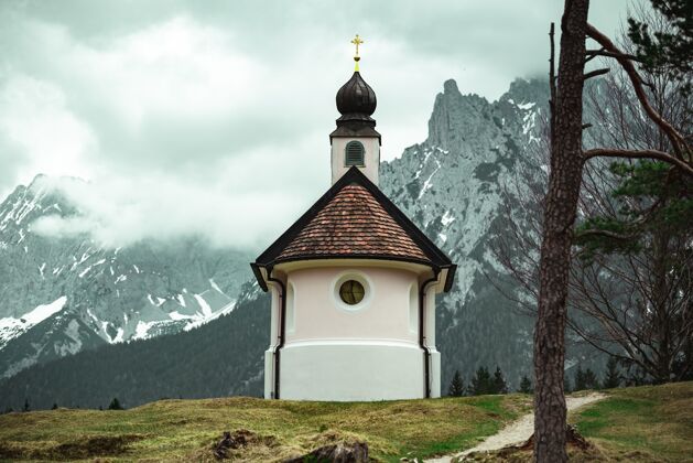 文化美丽的小天主教堂在巴伐利亚阿尔卑斯山脉传统山天空