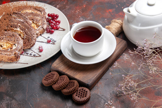 茶碟半俯视图美味饼干卷与饼干和茶在黑暗的桌子上甜饼饼蛋糕饼干食物营养品