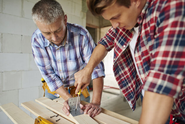 工具特写有经验的木匠和他的年轻雇员木材工艺木匠