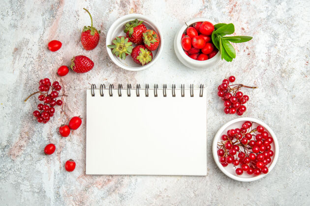 新鲜在白色的桌子上用记事本俯瞰红色水果浆果红色水果食品甜点冬青