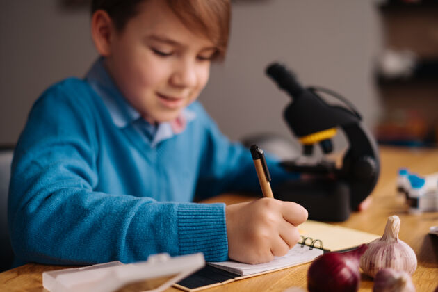 毛衣一年级男生在家用显微镜学习制造课家庭学习