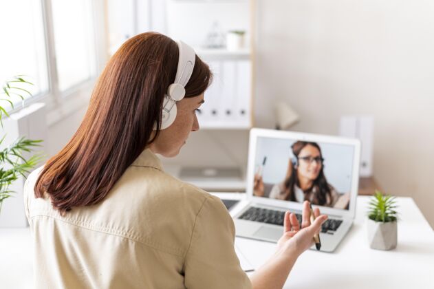 技术工作中的女人正在笔记本电脑上进行视频通话办公桌工作办公室