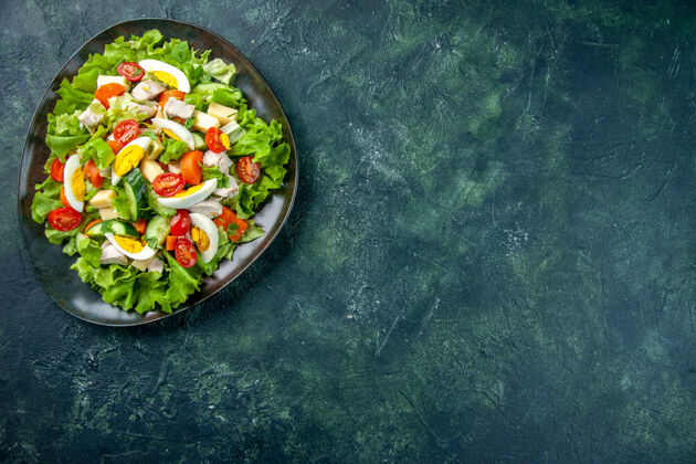 肉上图为自制美味沙拉 黑色盘子放在绿黑色混合色桌子的右侧 有自由空间免费食物烹饪