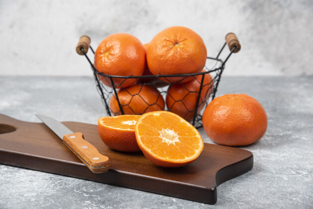 天然石桌上放着一块木板 上面放着一把刀 上面放着多汁的橙子片提神美味成熟