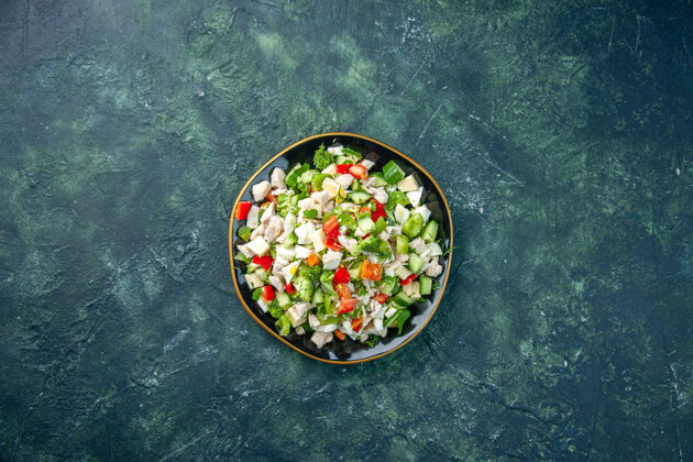 晚餐顶视图蔬菜沙拉包括奶酪黄瓜和番茄深蓝色背景色健康午餐新鲜食物餐碗奶酪新鲜