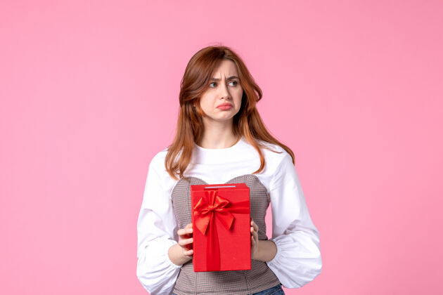 礼品正面图：年轻女性 红色包装 粉色背景 三月横向性感礼物 香水照片 平等女性香水礼品包装