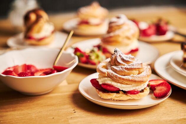 零食特写镜头美味奶油泡芙与草莓在木桌上浆果泡芙巧克力