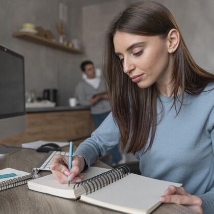 媒体在媒体领域工作的女人在笔记本上写东西的侧视图计算机工作男人