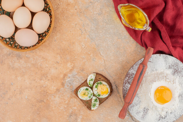 蛋黄美味的烤面包 大理石桌上放着几个鸡蛋和油可口食物面包