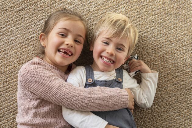 肖像顶视图年轻的兄弟姐妹拥抱男孩孩子笑脸
