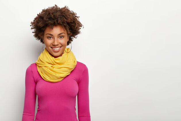 女性帅气的时尚女性 非洲式发型 穿着粉色运动衫 戴着黄色围巾 笑得很开心微笑满意时尚