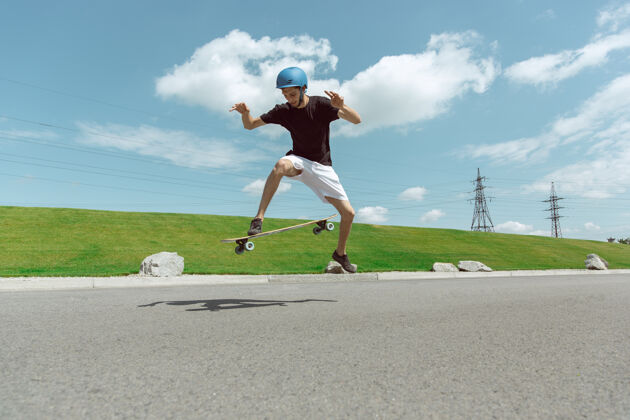 溜冰者在阳光明媚的日子里 滑板运动员在城市的街道上玩花样练习平衡锻炼