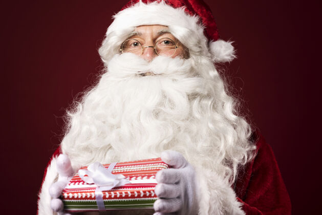 携带圣诞老人带着一个红色背景的礼盒欢呼胡须白人种族