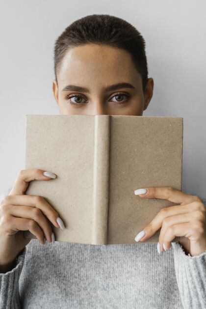 年轻用笔记本遮住脸的女人独特多样性成人